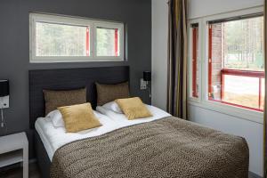 库萨莫库萨莫阙平基假日俱乐部高级公寓的一间卧室配有带2个枕头的床和2个窗户。