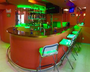 巴塞尔Hotel Locanda的餐厅内带绿色酒吧凳的酒吧