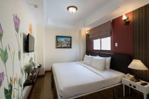 胡志明市Asian Ruby Center Point Hotel & Spa的酒店客房设有白色的床和电视。