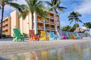 皮尔斯堡Hutchinson Island Hotel的酒店前的海滩上摆放着一排色彩缤纷的椅子