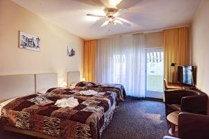 柏林卡尔梅耶酒店的酒店客房配有两张床和吊扇。