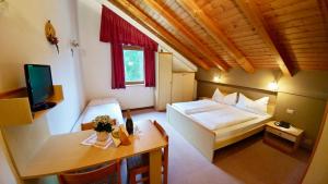 圣卡夏诺萨斯德拉西亚营地旅馆的一间卧室配有一张床、一张桌子和一台电视