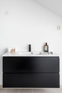 奥斯陆Frogner House - Grünerløkka的黑色浴室水槽和白色台面