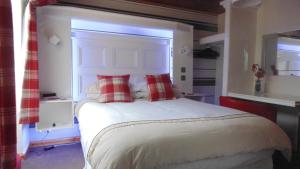 阿尔内斯Westmore Bed & Breakfast的卧室配有带红色枕头的大型白色床