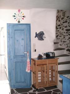 伊利达3-level doll house in Kea Ioulida/Chora, Cyclades的一间有蓝色门的房间,墙上有一条鱼