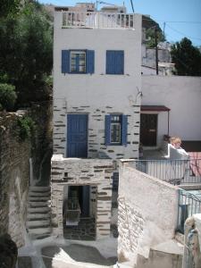 伊利达3-level doll house in Kea Ioulida/Chora, Cyclades的白色的建筑,上面有蓝色百叶窗