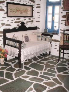 伊利达3-level doll house in Kea Ioulida/Chora, Cyclades的石墙房间内的沙发