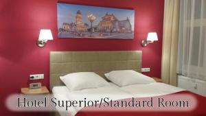 柏林维塔柏林展览馆酒店的酒店高级标准间内的一张床位,设有红色的墙壁
