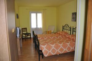 Arcumeggia洛坎达皮托尔宾馆的卧室配有一张床和一张桌子及椅子
