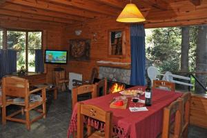 拉安戈斯图拉镇Paisaje Bandurrias的小屋内带桌子和壁炉的用餐室