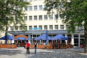 马格德堡热特斯瓦格酒店的站在建筑物前面的男人和女人