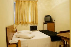 陶巴特Antico Plaza Hotel的小房间设有床和电视