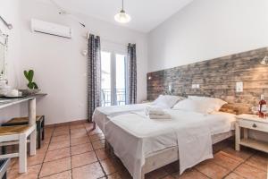纳乌萨玛达琪酒店的一间卧室设有一张大床和砖墙