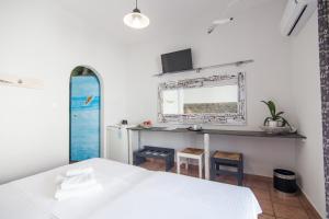 纳乌萨玛达琪酒店的卧室配有白色的床和镜子