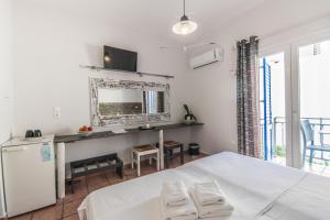 纳乌萨玛达琪酒店的一间卧室配有一张床和一张带镜子的书桌