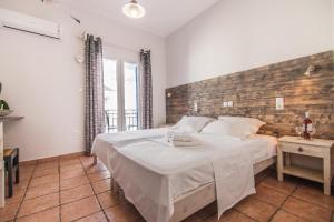 纳乌萨玛达琪酒店的一间卧室设有一张带木墙的大床