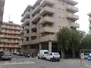 玛丽安迪安多拉Appartamento a Andora的一座大型建筑,前面有汽车停放