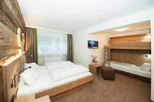 萨尔巴赫贝肯霍夫酒店的一间卧室配有两张床和一张双层床。
