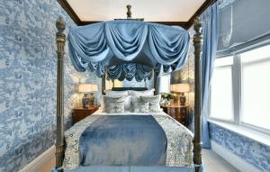 伦敦圣多米尼哥别墅酒店的蓝色卧室,配有一张带天蓬的床