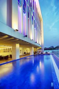 马卡萨金郁金香伊萨索望加锡酒店的一座大型建筑,前面设有一个游泳池