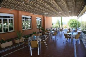 洛佩斯港格拉纳达埃斯库多酒店的一间带桌椅的餐厅和庭院