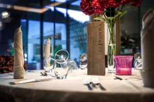 圣卡夏诺Hotel La Fradora - Dolomites Hotel的酒杯桌子和花瓶