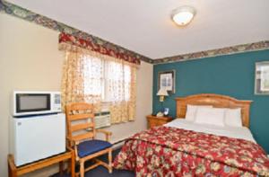 斯托宁顿美洲最佳价值客栈 - 斯托宁顿 的配有一张床和一把椅子的酒店客房