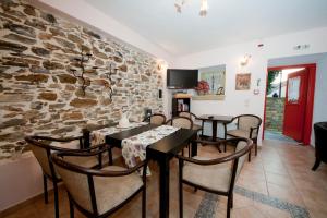 NeochoriArhontiko Prepala的一间带桌椅和石墙的用餐室