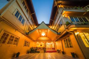 清莱Nakaraj Princess Chiang Rai - Walking Street的一座古老的建筑,晚上有明亮的庭院