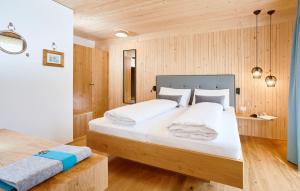 贝曹Hotel Gretina的一间卧室设有一张大床和木墙