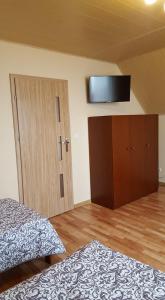 Krajno PierwszeNoclegi Na Wzgórzu的卧室配有一张床,墙上配有电视