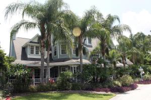 芒特多拉Heron Cay Lakeview Bed & Breakfast的前院内棕榈树的房子