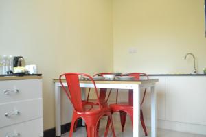 Kota Samarahan克塔三马拉汗我的宾馆的厨房配有两把红色椅子和白色桌子