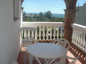 博罗尼亚Apartamentos Bolonia Paraiso的阳台上配有一张白色的桌子和两把椅子