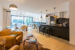 波尔多La Maison Odeia Bordeaux Centre的客厅以及带沙发和桌子的厨房。
