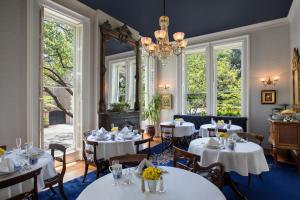 萨凡纳汉密尔顿-特纳酒店的餐厅配有白色的桌椅和吊灯