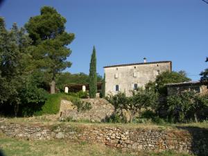 昂迪兹Gîtes du Mas Icard的石墙和田野中的建筑