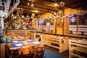 米戈韦Edelweiss Carpathians Migovo的一间带木桌椅的餐厅和一间酒吧