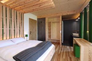 斯拉德明阿尔姆普拉耐度假屋的卧室设有白色大床和木墙