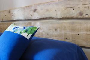 因佩里亚A Baracca du Pei的一张带木墙的床上蓝色枕头