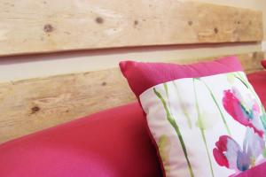 因佩里亚A Baracca du Pei的红色沙发上的枕头和木墙