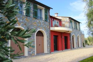 因佩里亚A Baracca du Pei的一座砖砌建筑,设有红色的门和阳台