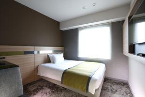 仙台仙台阿尔蒙特酒店的一间小卧室,配有床和窗户
