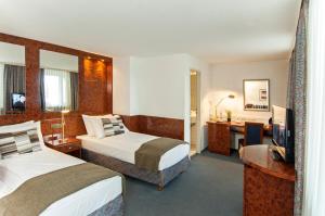 科隆阿列格鲁酒店的酒店客房配有两张床和一张书桌