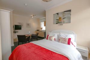 布莱克浦布莱克浦酒店的卧室配有红色和白色的床和书桌。