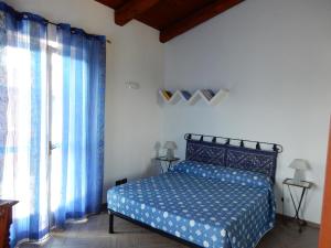 卡斯蒂廖内法莱托阿尔瓦特罗斯度假屋的一间卧室配有蓝色的床和蓝色窗帘