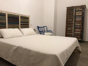 滨海波利尼亚诺Zì Marì - Via Sirene的卧室配有一张白色大床和一张蓝色椅子