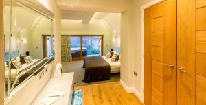 温德米尔Applegarth Villa Hotel & Restaurant (Adult Only)的一间卧室配有一张床和一面大镜子