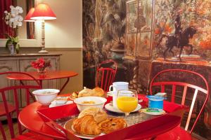 巴黎Hôtel Perreyve - Jardin du Luxembourg的一张桌子,上面放着一盘食物和橙汁