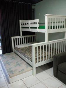 马瑙斯阿茹里卡巴8号公寓的带沙发的客房内的2张白色双层床